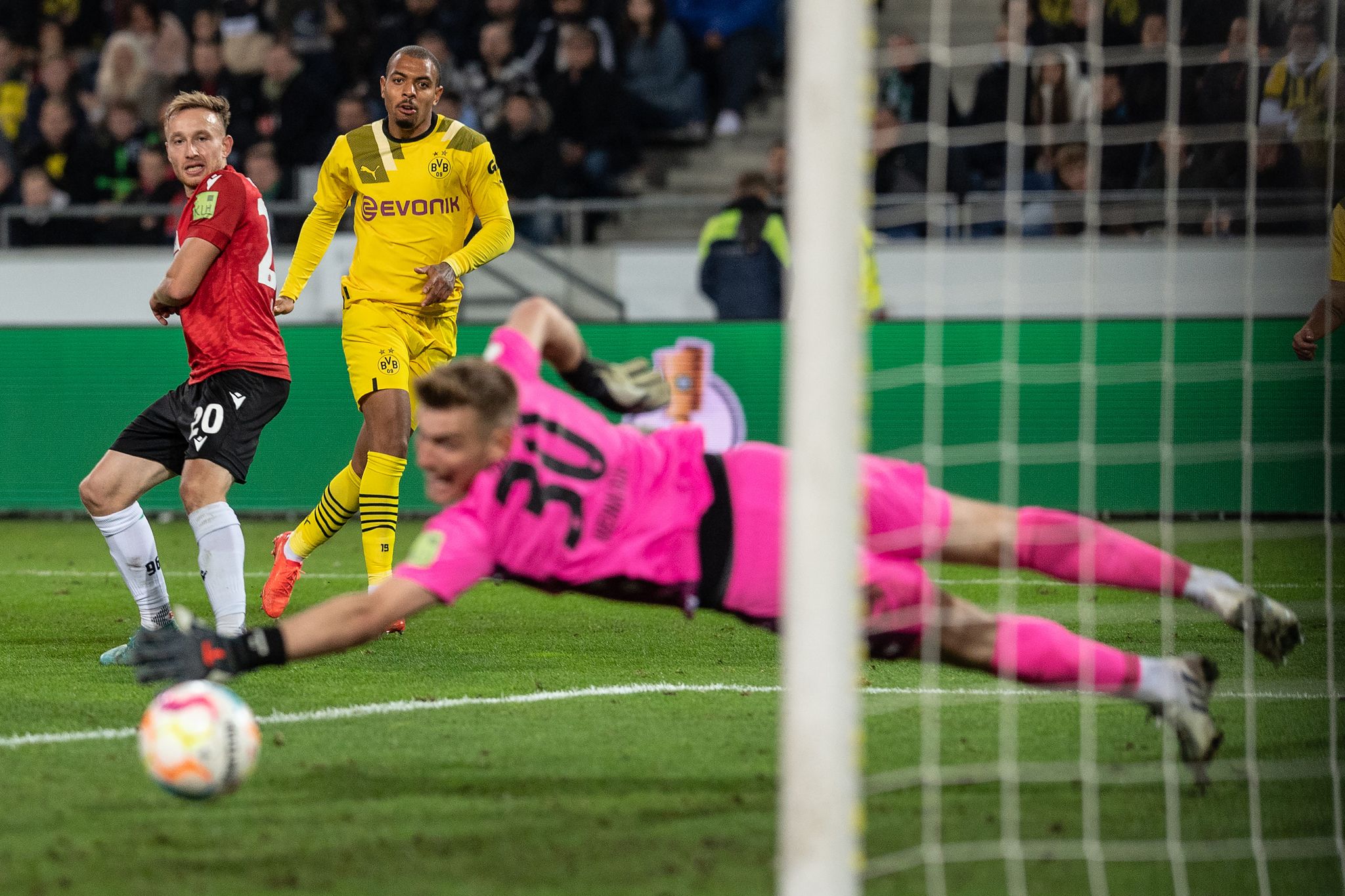 Dortmunds Donyell Malen (M) Schießt Auf Das Tor Von Hannovers Torwart Leo Weinkauf (r).