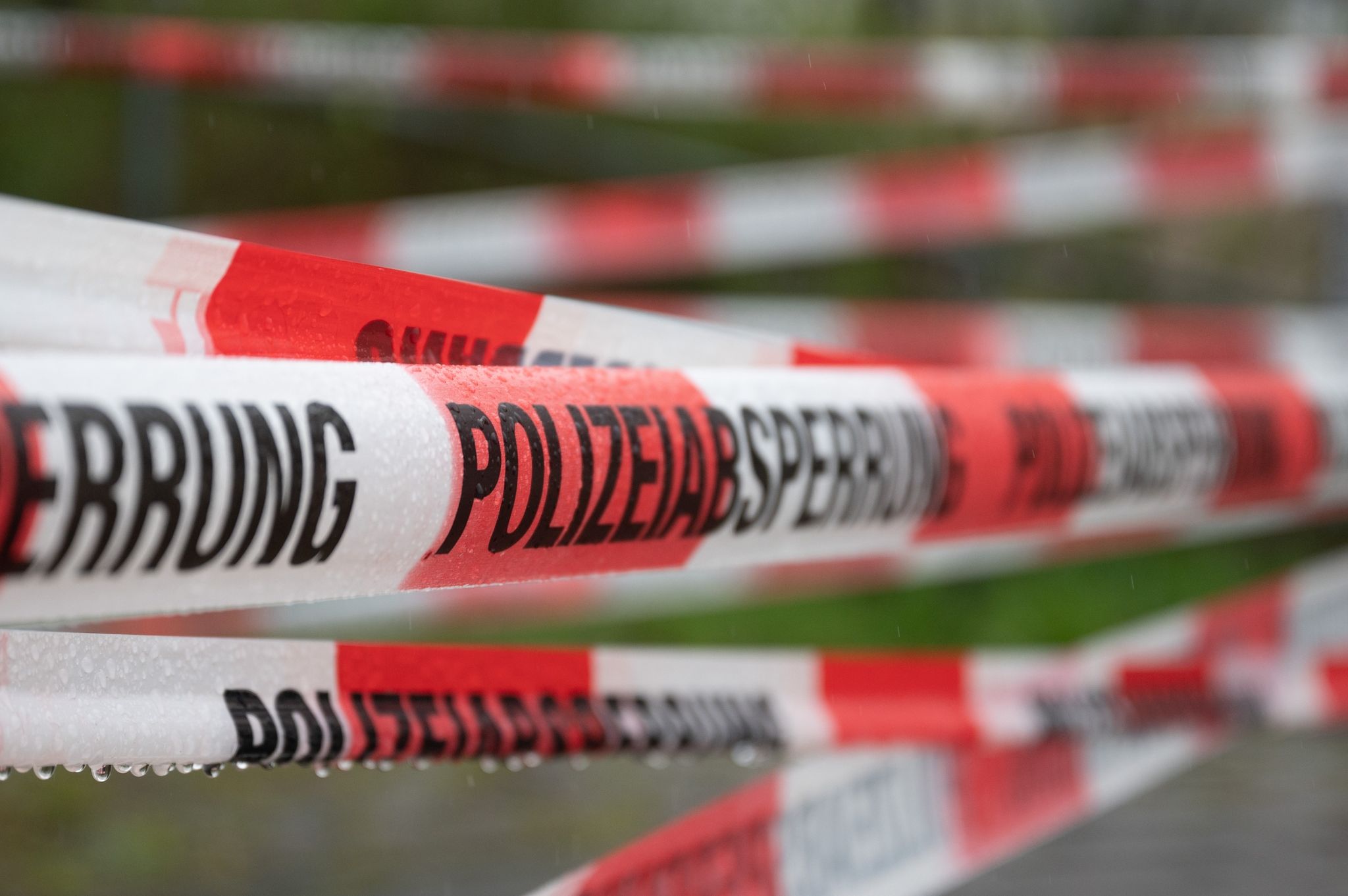 Ein Einsatzort Der Polizei Ist Mit Flatterband Abgesperrt.