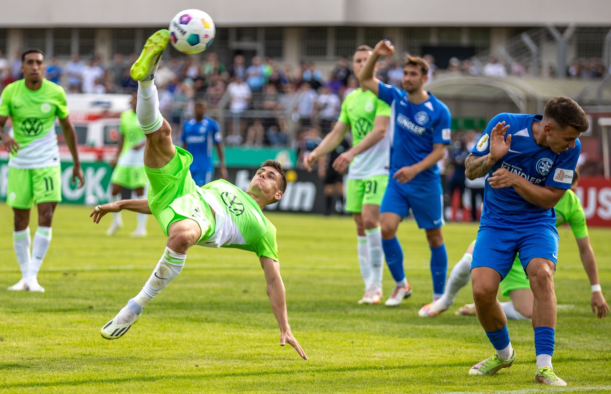 Wolfsburgs Joakim Maehle (l) Netzt Den Ball Mittels Fallrückzieher Ein.