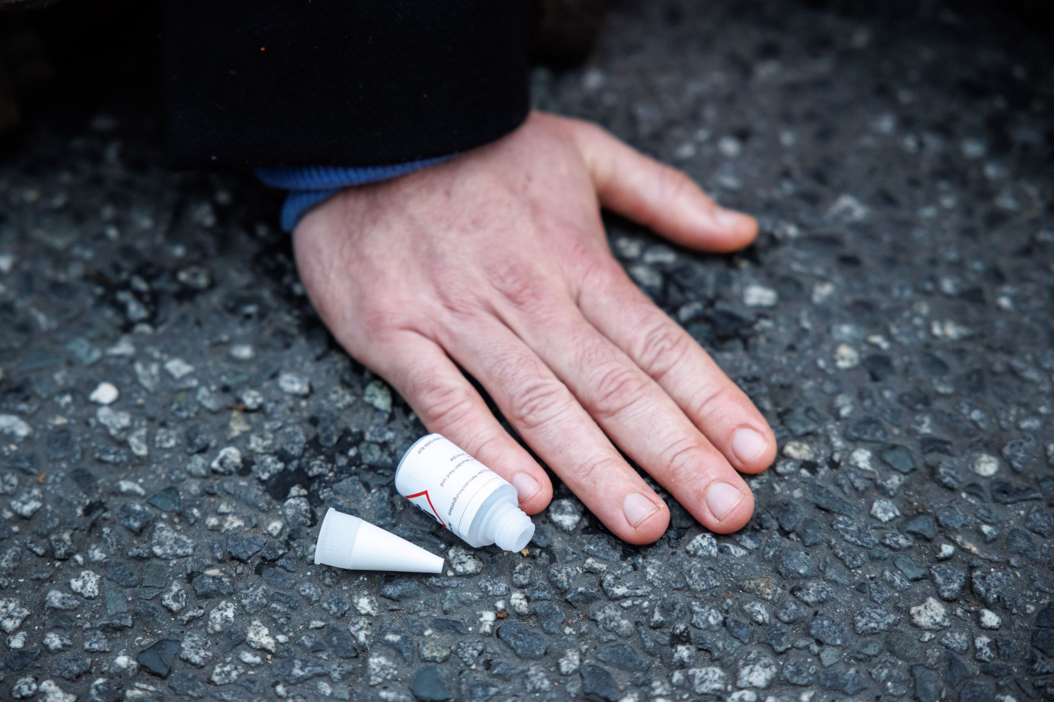 Ein Aktivist Der Klimaschutz-Initiative «Letzte Generation» Ist Mit Der Hand Auf Die Straße Geklebt.