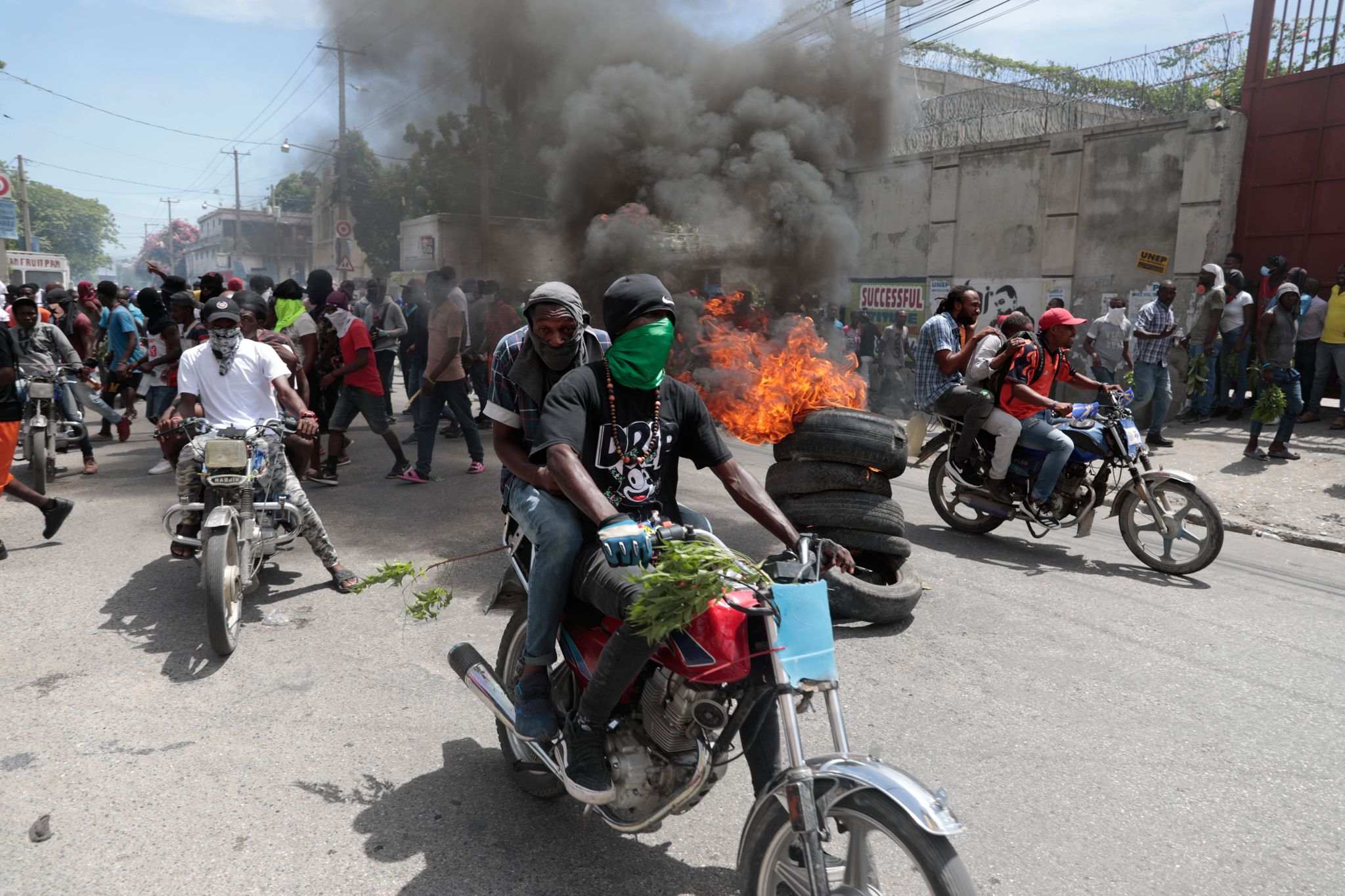 Demonstranten Fahren Mit Ihren Motorrädern An Einer Brennenden Barrikade Vorbei, Während Sie Gegen Die Unsicherheit In Port-au-Prince Protestieren.