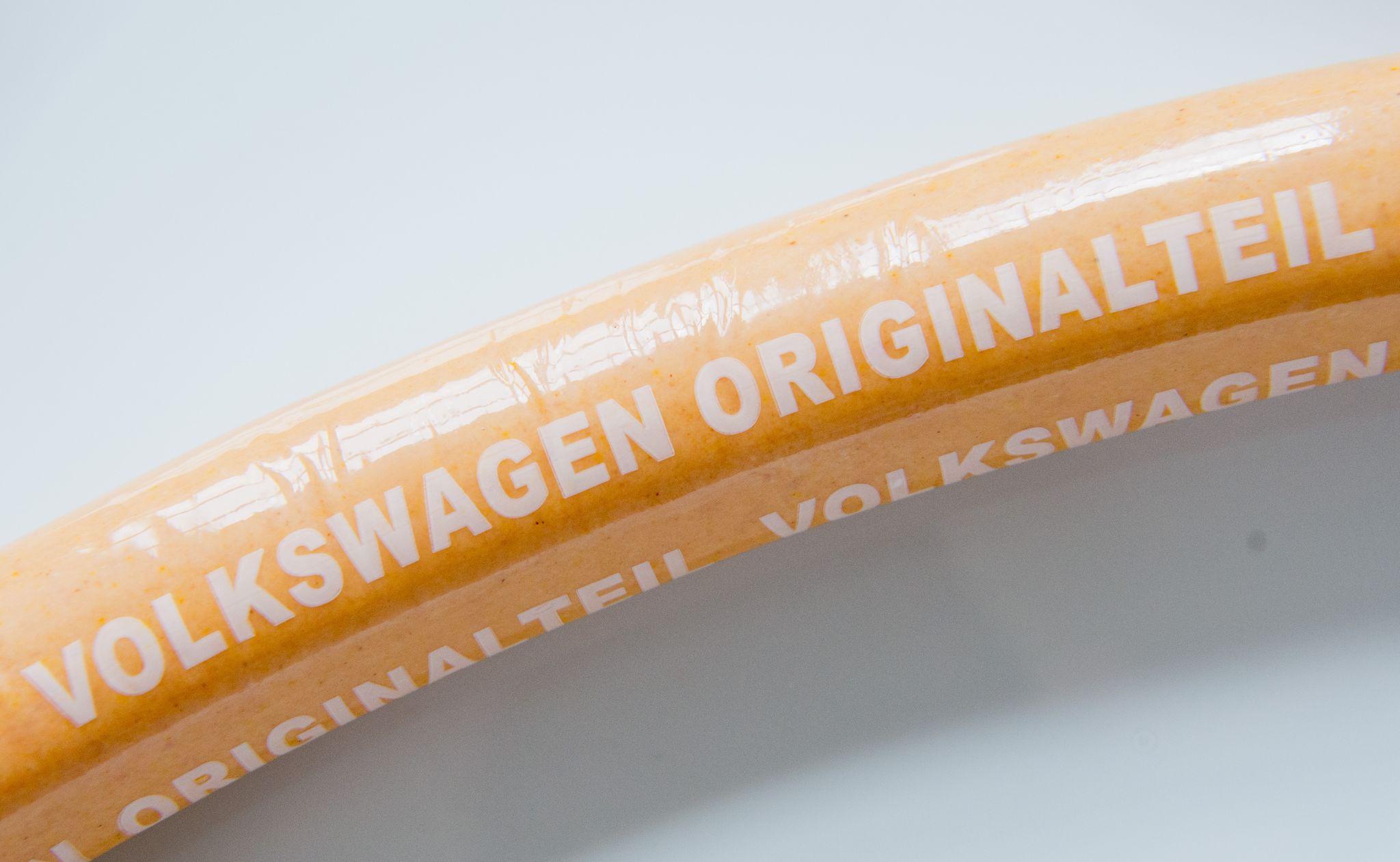 Eine Currywurst Mit Aufschrift «Volkswagen Originalteil» Liegt Auf Einem Teller.