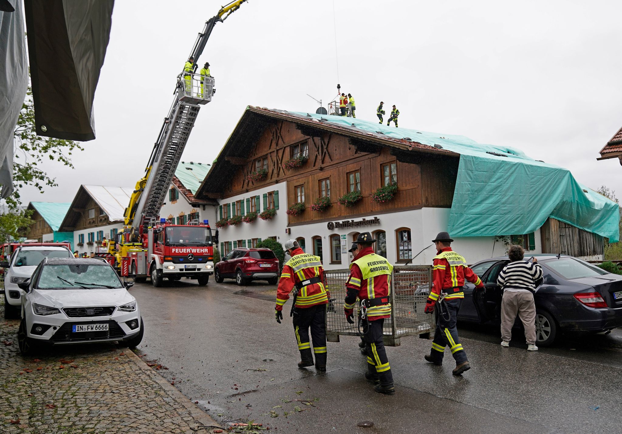 Arbeiter Und Feuerwehrleute Beseitigen Die Unwetter-Schäden Im Oberbayerischen Bad Bayersoien. Bei Dem Unwetter Wurden Viele Dächer Beschädigt.