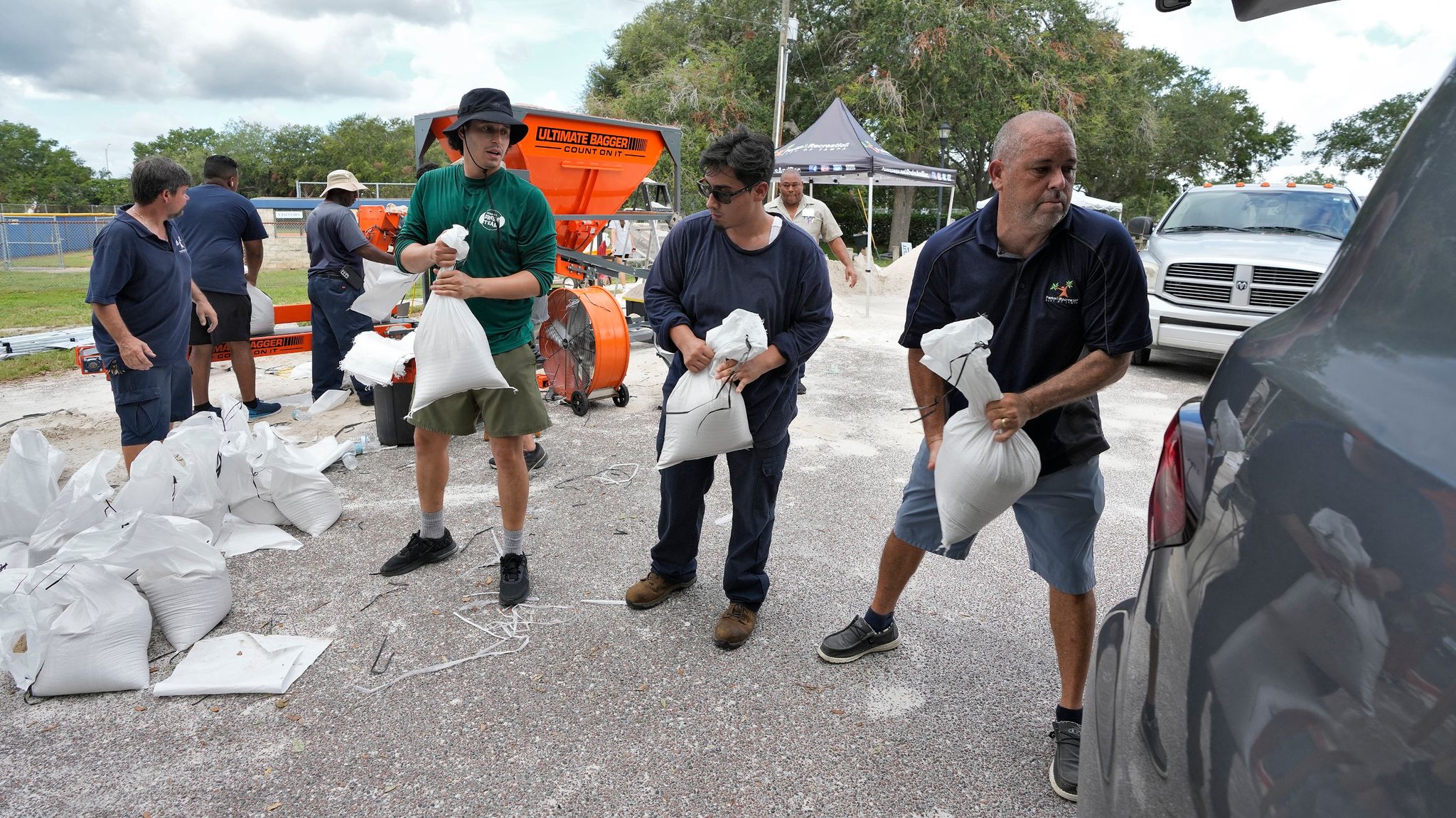 Mitarbeiter Der Park- Und Freizeitbehörde Von Tampa In Florida Helfen Anwohnern Beim Verladen Von Sandsäcken.
