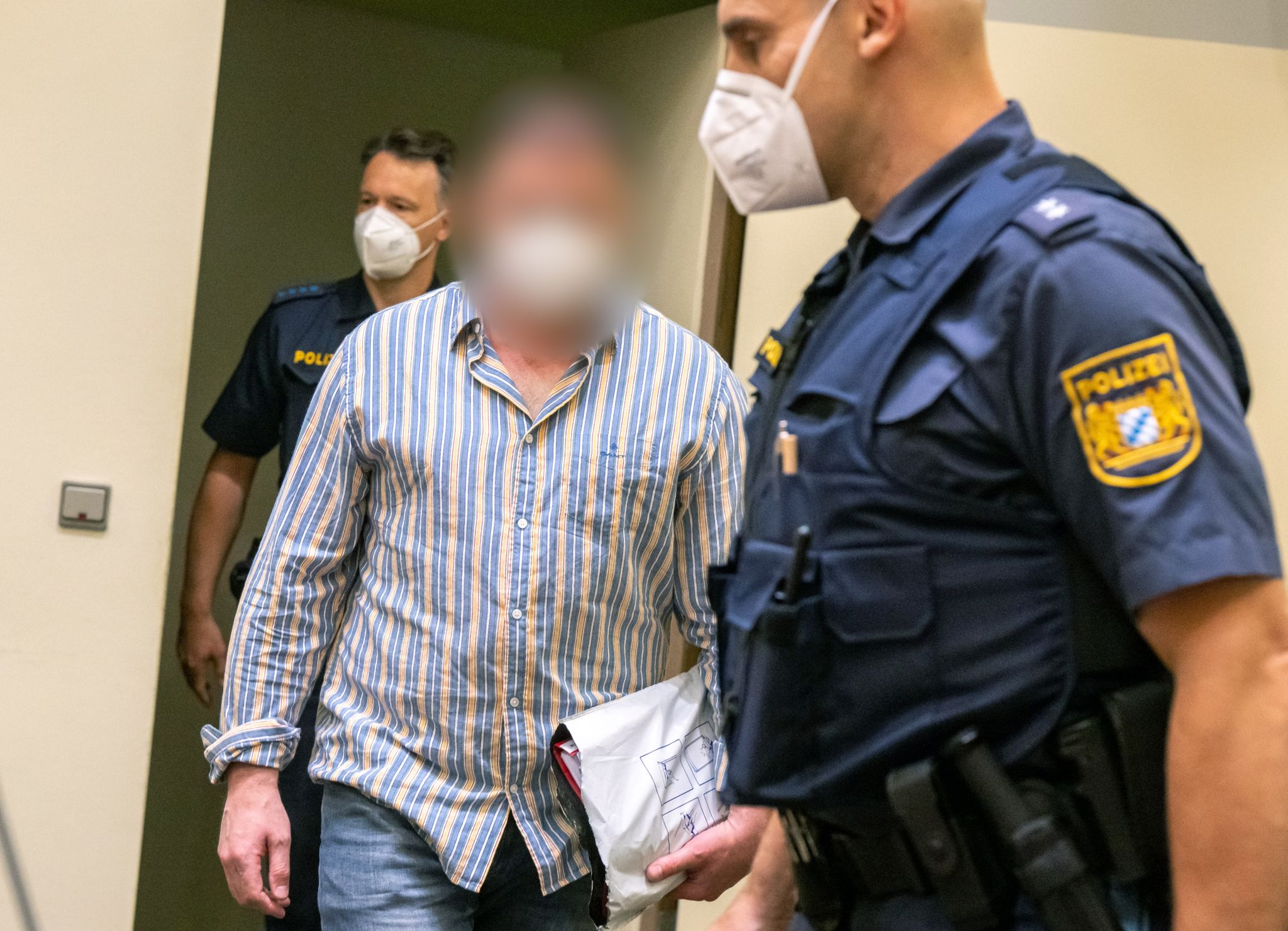 Der Angeklagte Wird Von Der Polizei In Den Gerichtssaal Geführt. Der Russe Soll Im Auftrag Der Tschetschenischen Regierung Den Mord An Einem In Deutschland Lebenden Oppositionellen Und Kritiker Des Tschetschenischen Präsidenten Kadyrow Vorbereitet Haben.