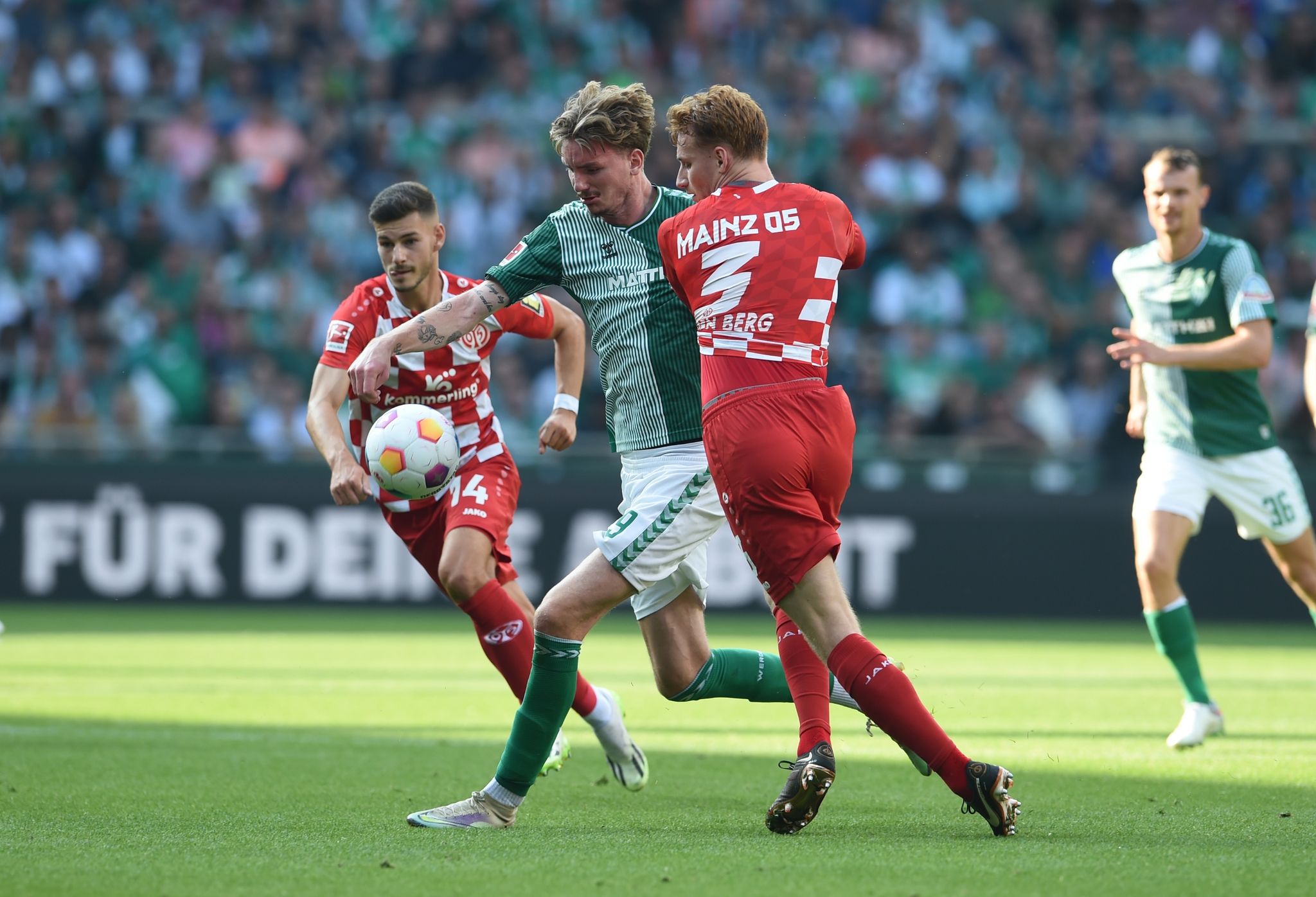 Bremens Nick Woltemade (M) Kämpft Gegen Mainz Tom Krauß (l) Und Sepp Van Den Berg Um Den Ball.