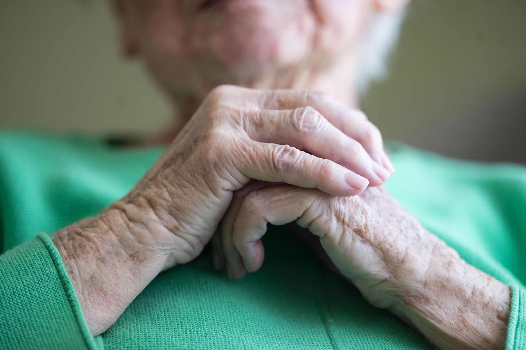 Eine Seniorin Faltet Ihre Hände.