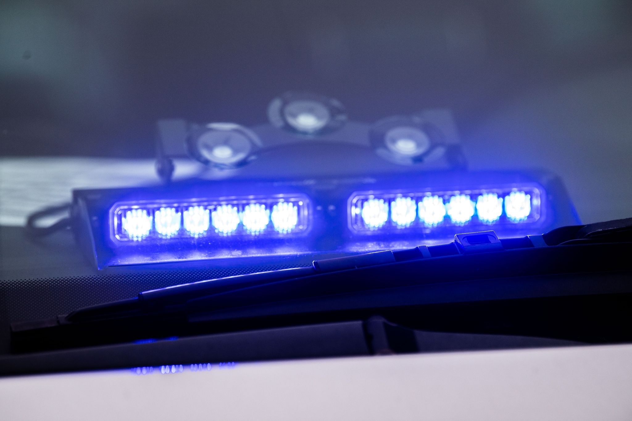 Ein Blaulicht Leuchtet Unter Der Frontscheibe Eines Einsatzfahrzeugs Der Polizei.