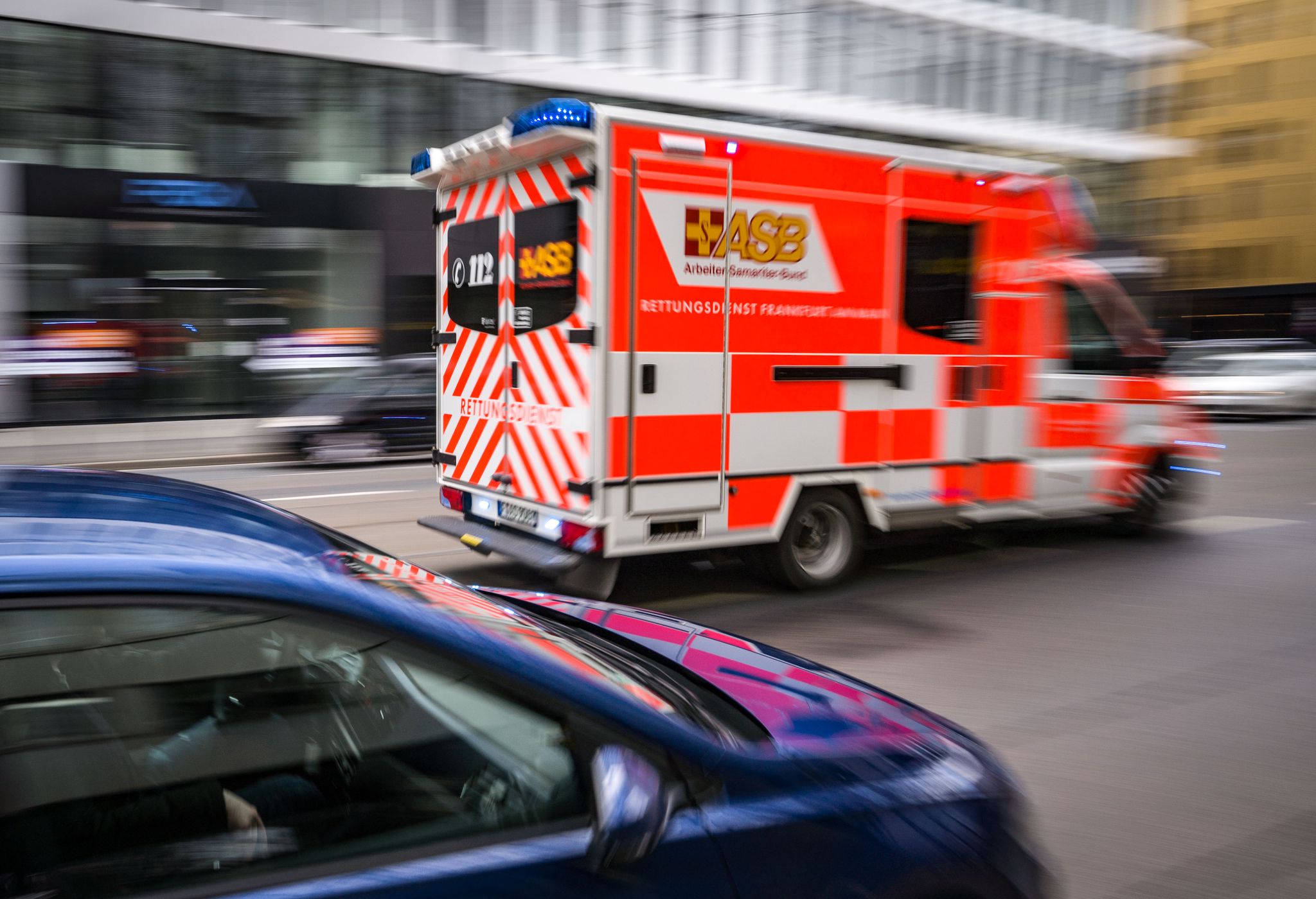 Ein Rettungswagen Des Arbeiter-Samariter-Bundes (ASB) Ist Mit Blaulicht Unterwegs.