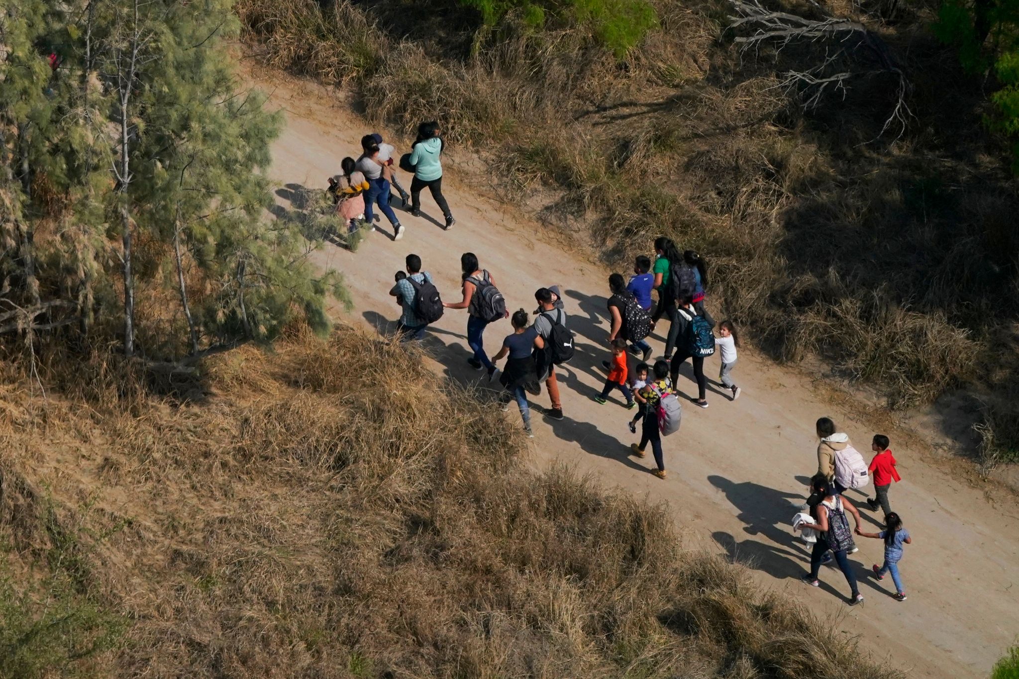 Migranten Gehen Einen Feldweg Entlang, Nachdem Sie Die Grenze Zwischen Den USA Und Mexiko überquert Haben.