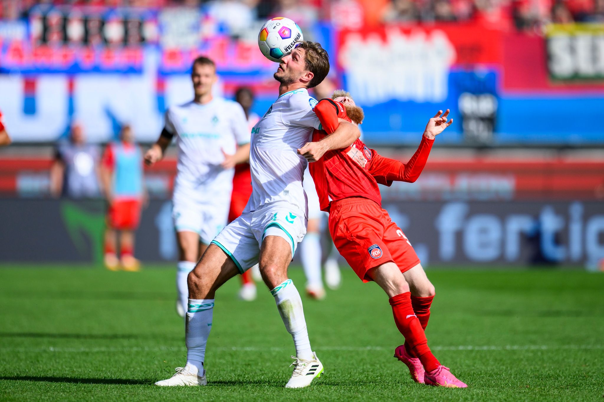 Bremens Niklas Stark (l) In Aktion Gegen Heidenheims Jan-Niklas Beste (r).