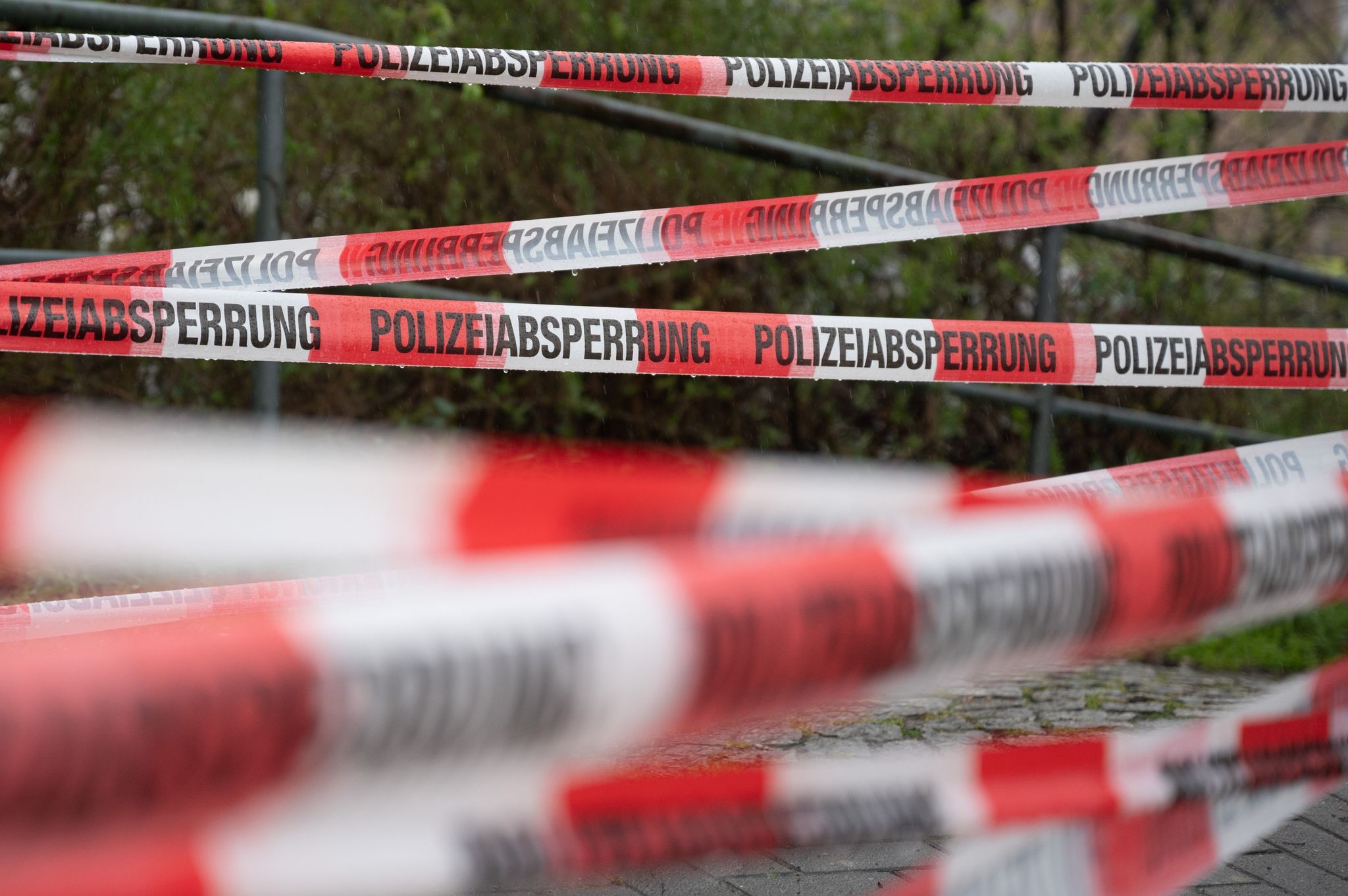 Ein Einsatzort Der Polizei Ist Mit Flatterband Abgesperrt.