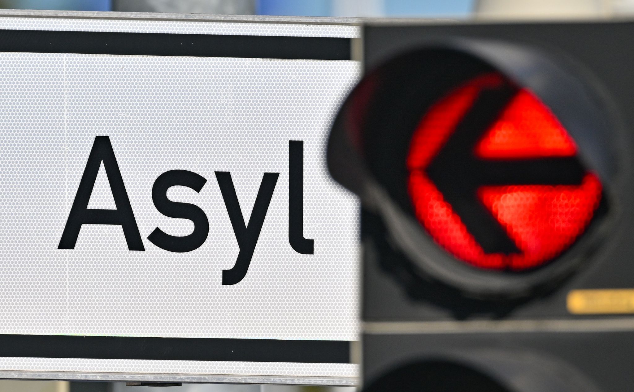 Eine Rote Ampel Leuchtet Vor Dem Wort «Asyl» Auf Einem Wegweiser Zur Erstaufnahme-Einrichtungen (EAE).