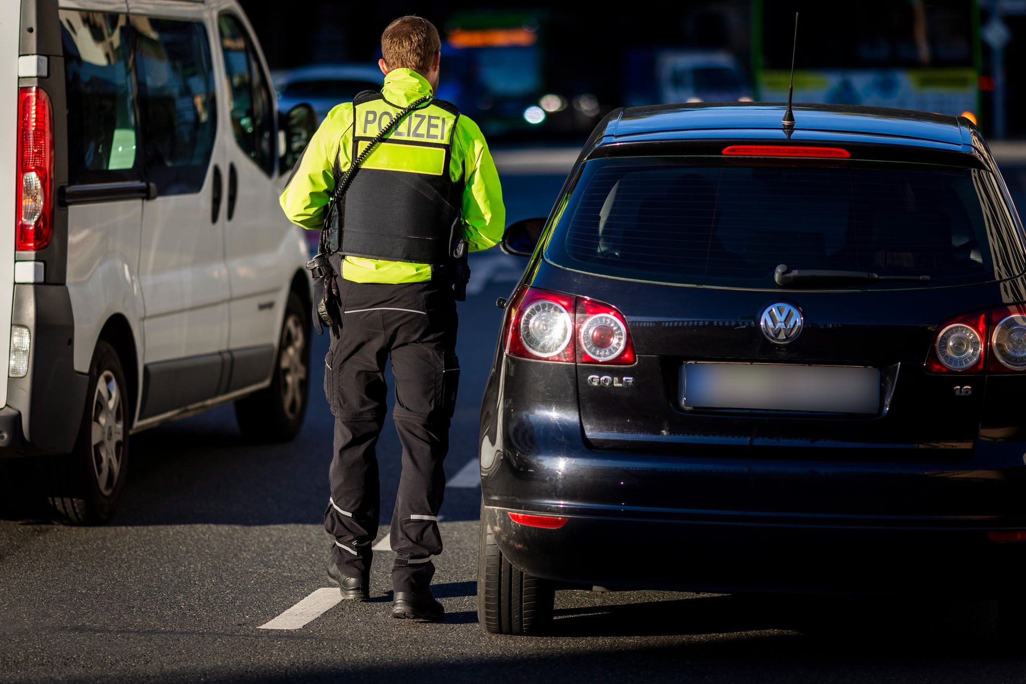 Ein Polizist Steht Bei Einer Verkehrskontrolle Neben Einem Auto.