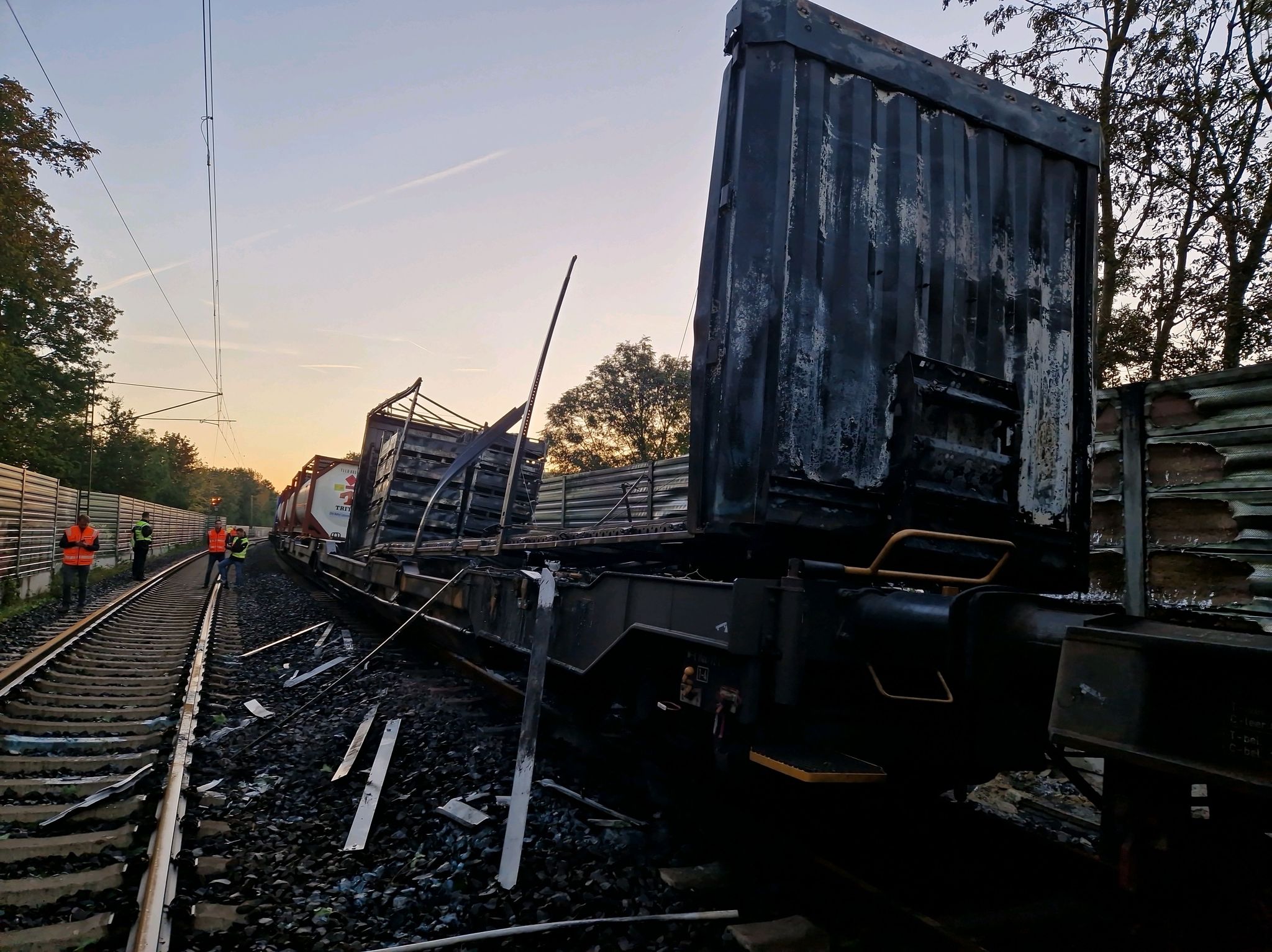 Beschädigte Waggons Eines Güterzugs Stehen Nach Einem Brand Auf Den Gleisen. Das Feuer Hatte Für Ausfälle Und Verspätungen Bei Der Bahn Gesorgt.