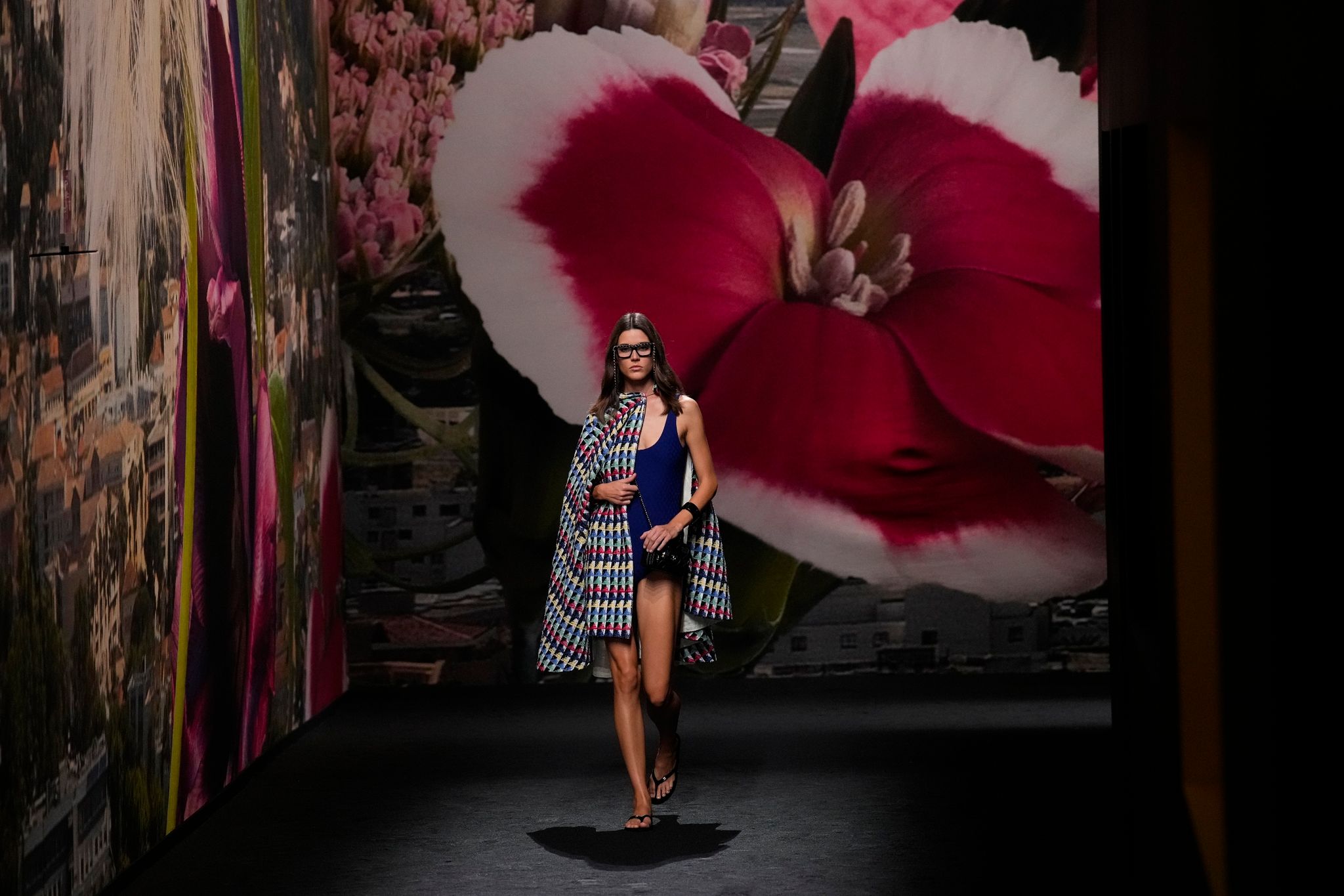 Ein Model Trägt Eine Kreation Von Chanel - Im Hintergrund: Eine Riesige Fototapete.