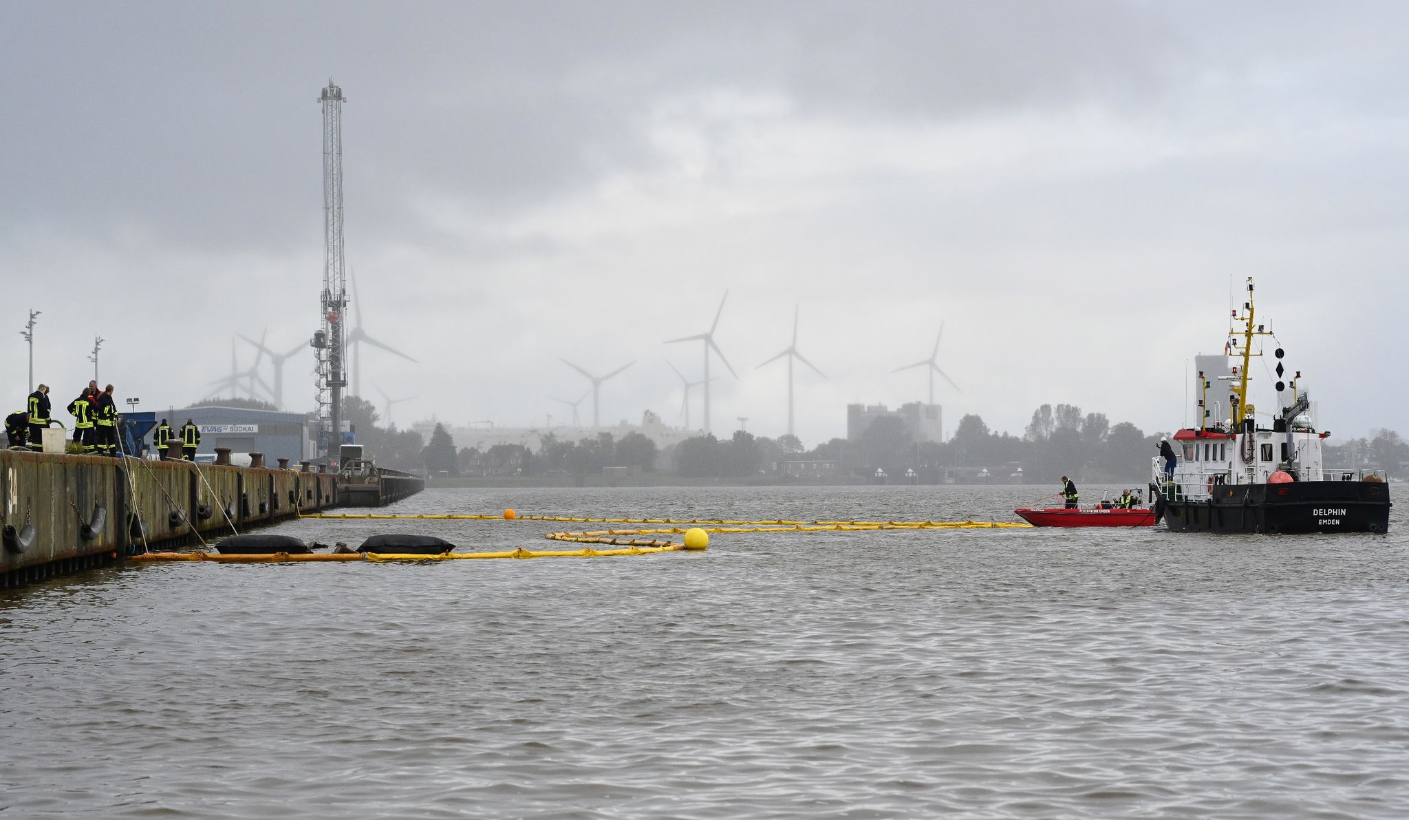Die Feuerwehr Bringt Mit Hilfe Von Zwei Schiffen Ölsperren An Der Unfallstelle Im Emdener Hafen Aus.