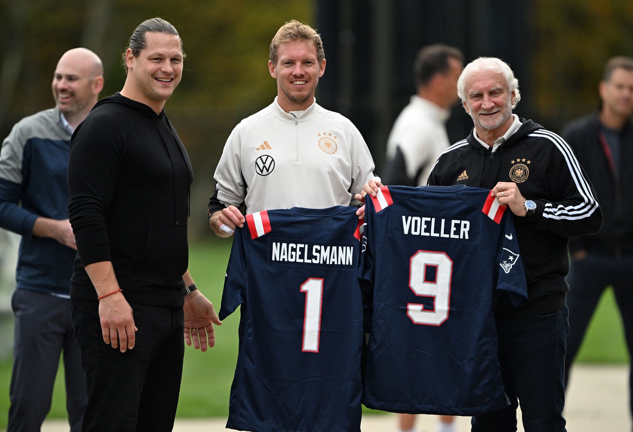 Ex-Football-Profi Markus Kuhn Präsentiert Mit Bundestrainer Julian Nagelsmann Und Sportdirektor Rudi Völler Die NFL-Trikots Der New England Patriots.