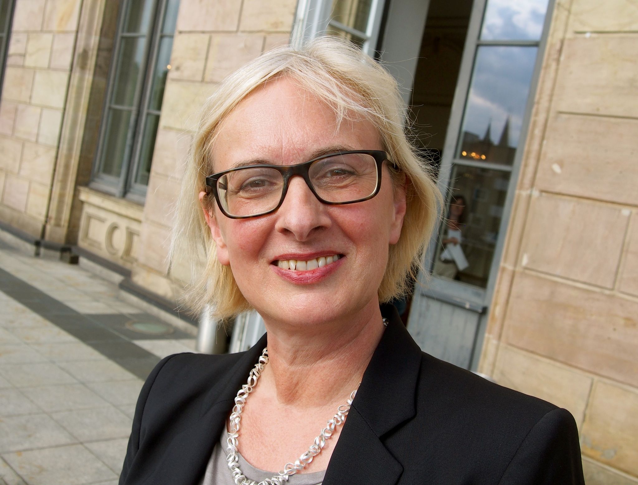 Dagmar Schlingmann blickt Vor Der Oper In Braunschweig In Die Kamera.