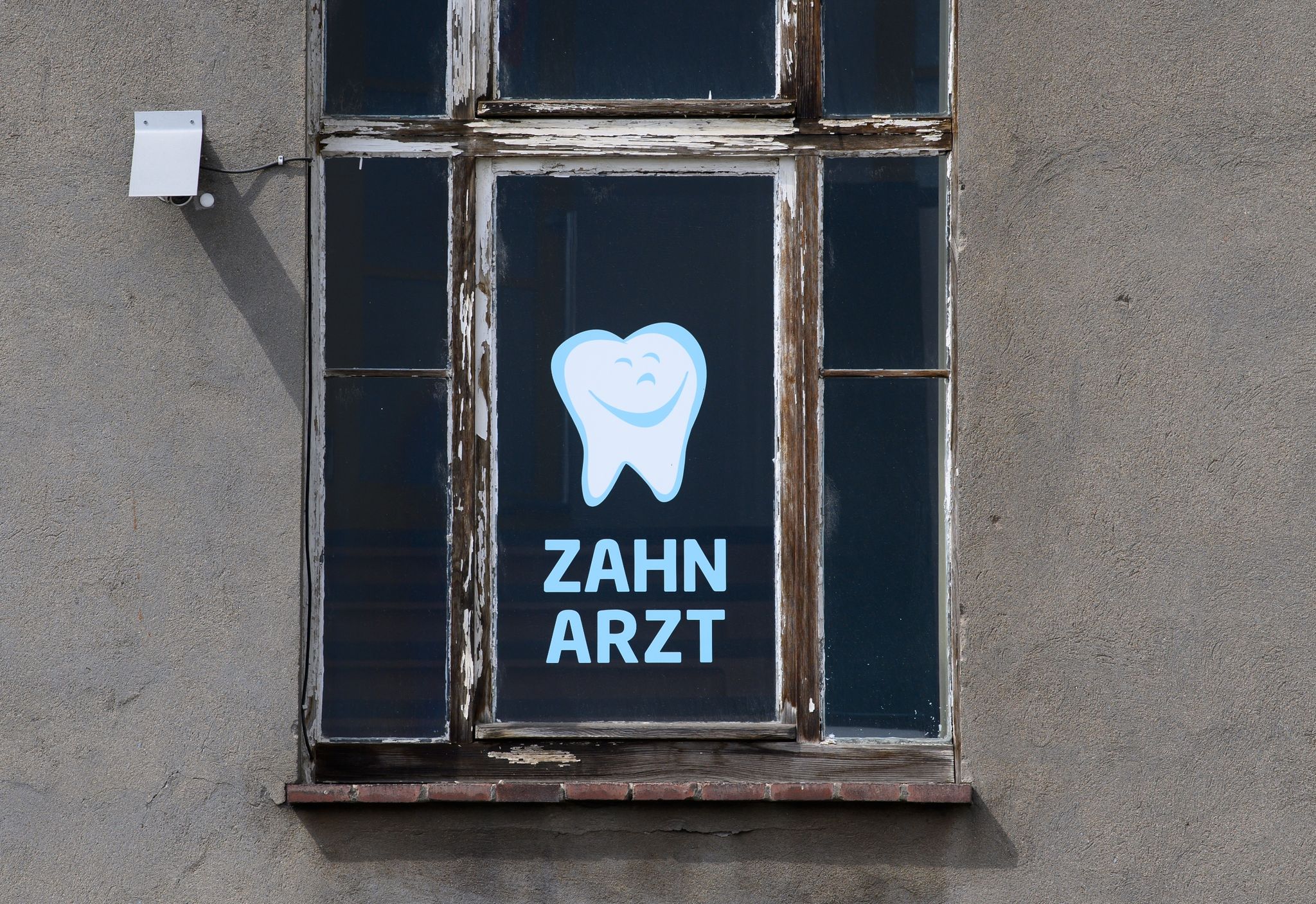 Zahnarzt Steht An Einem Fenster Eines Hauses Geschrieben, In Dem Sich Eine Zahnarztpraxis Befindet.