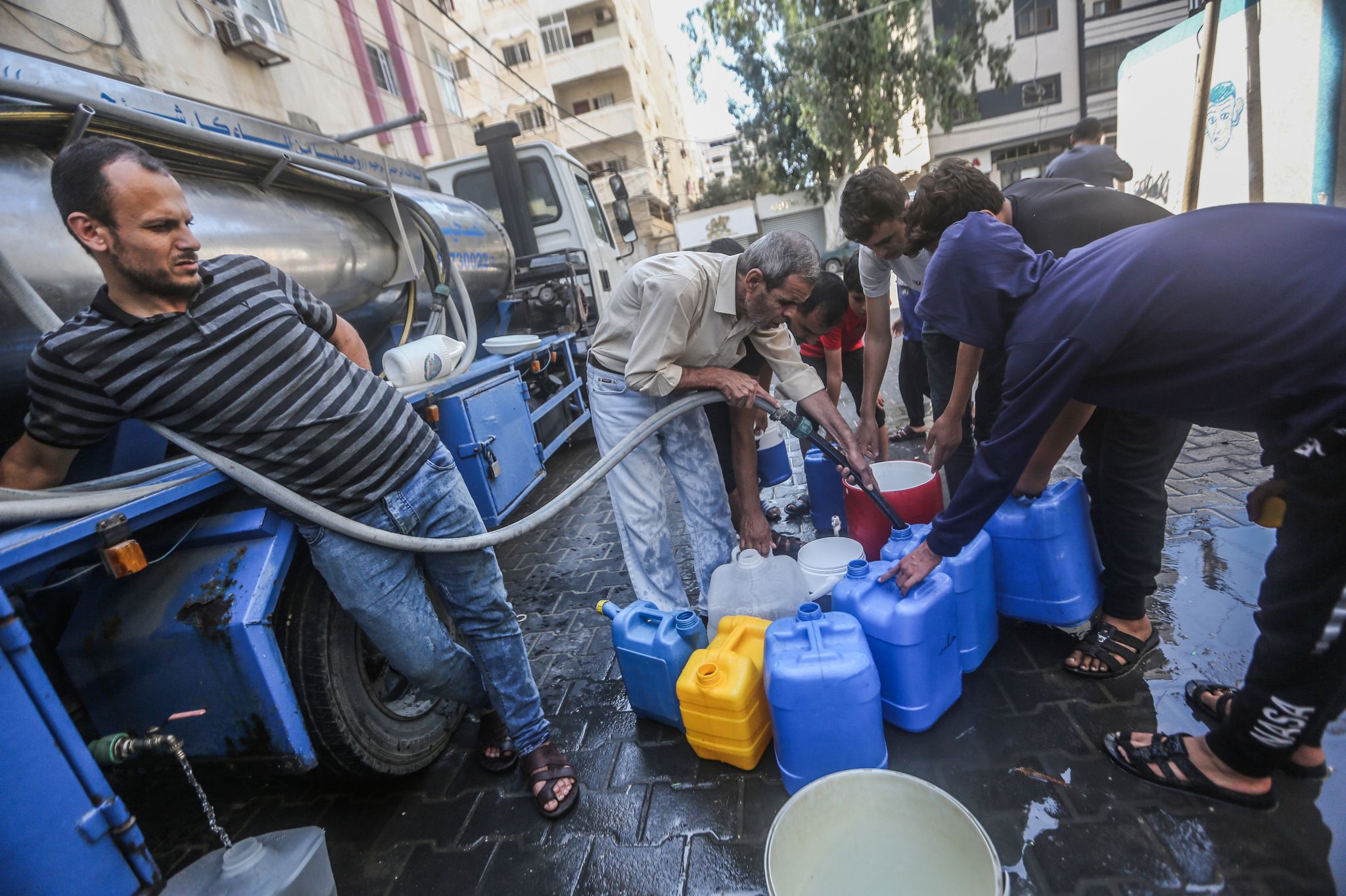 In Gaza-Stadt Wird Trinkwasser Verteilt. Nach Dem Massaker Der Islamistischen Hamas In Israel Bombardiert Die Armee Des Landes Den Dicht Besidelten Gazastreifen.