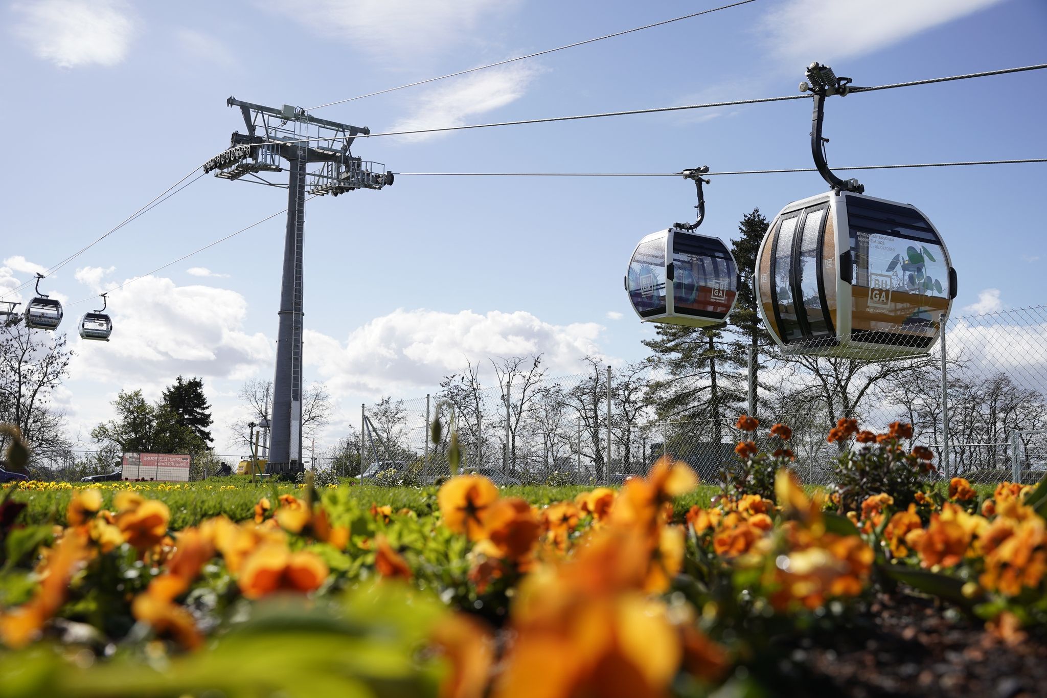 Kabinen Der Seilbahn Fahren Auf Dem Gelände Der Bundesgartenschau Hinter Einem Blumenbeet.