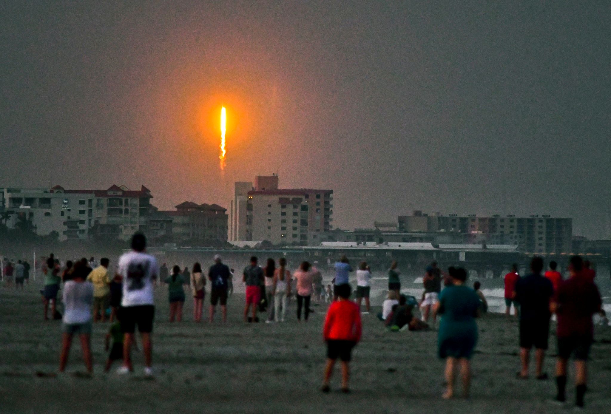 Menschen Beobachten Am Cocoa Beach Im US-Bundesstaat Florida, Wie Die SpaceX-Rakete In Cape Canaveral Abhebt.