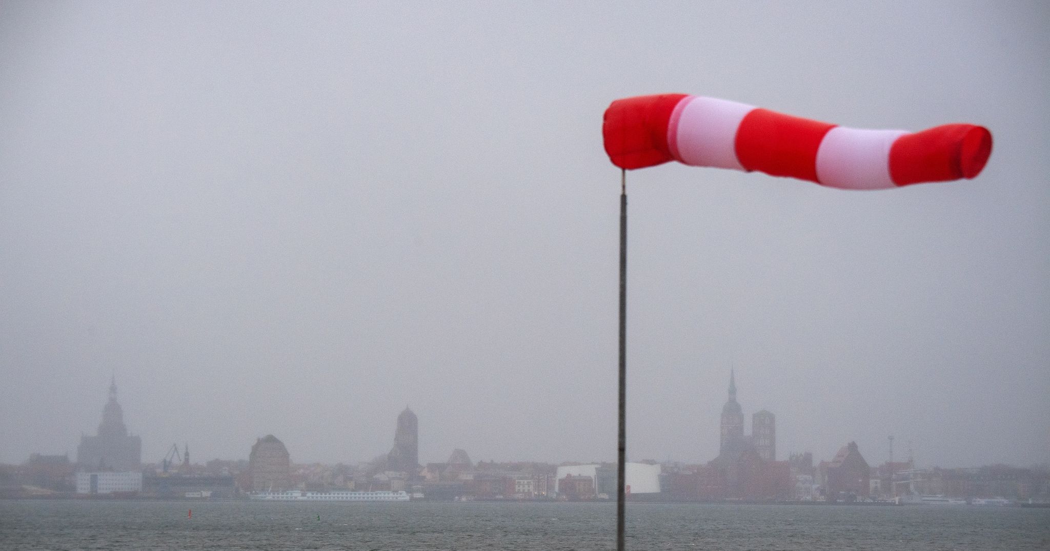Ein Windsack Steht Fast Horizontal In Der Luft Und Zeigt Den Wind An.
