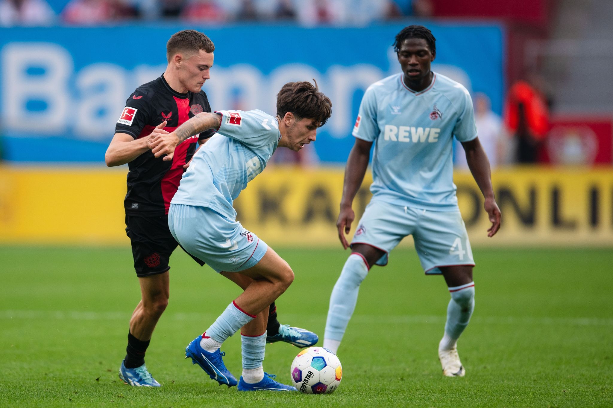 Leverkusens Florian Wirtz (l) Und Kölns Denis Huseinbasic Kämpfen Um Den Ball.