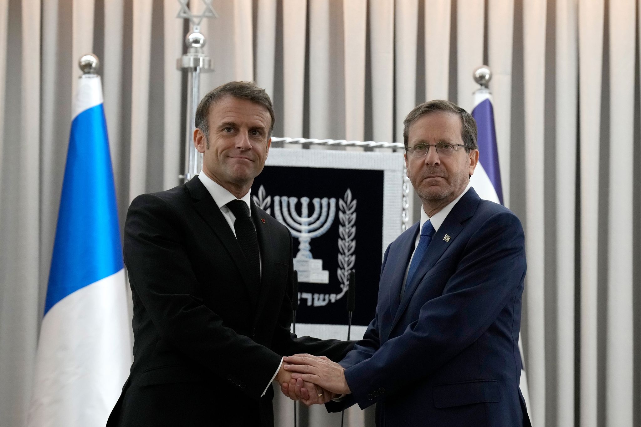 Emmanuel Macron (l), Präsident Von Frankreich, Schüttelt Izchak Herzog, Präsident Von Israel, Die Hand. Frankreichs Präsident Macron Ist Zu Einem Zweitägigem Besuch In Israel.