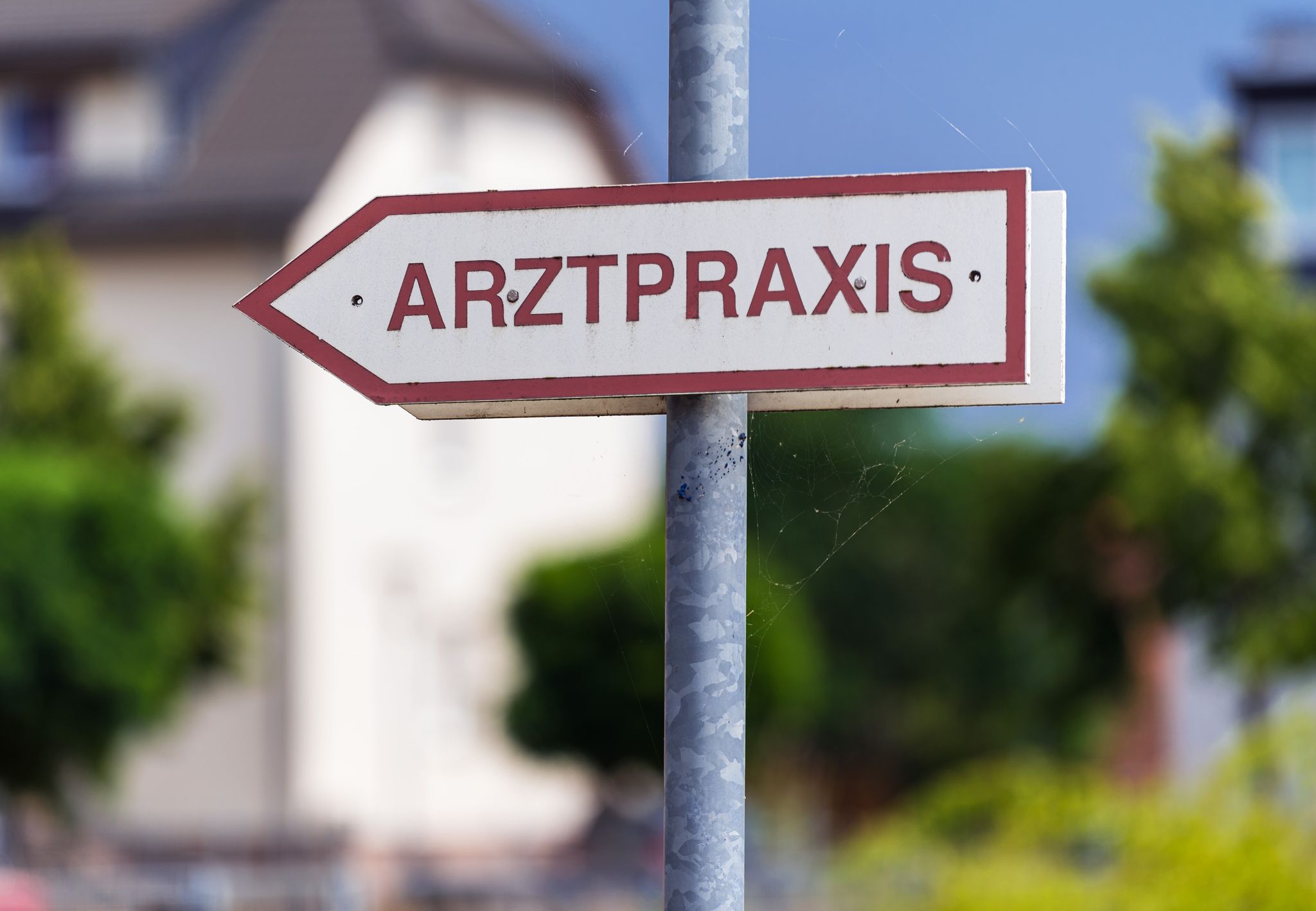 Ein Schild Weist Den Weg Zu Einer Arztpraxis.