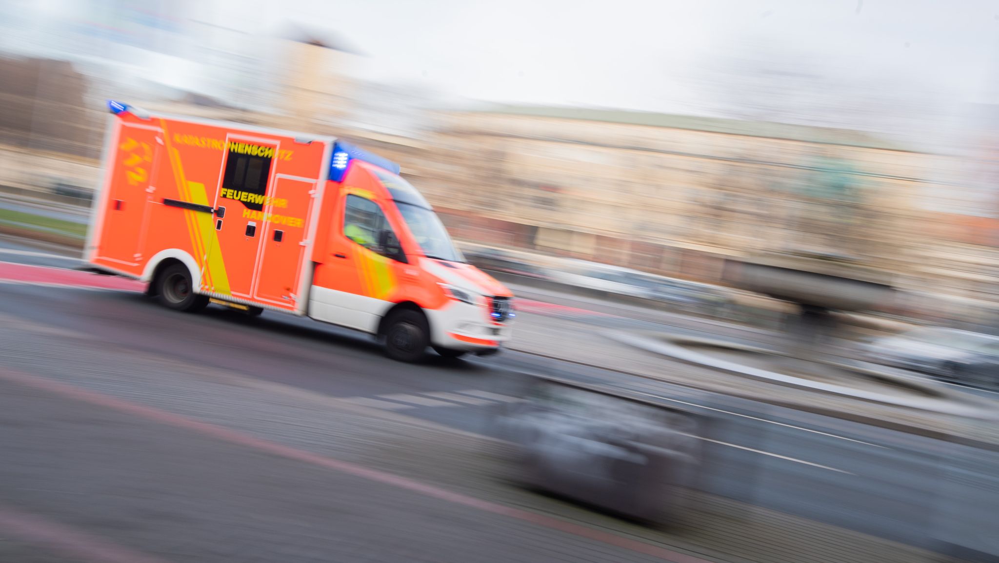 Ein Rettungswagen Der Feuerwehr Hannover Fährt Mit Blaulicht Durch Die Innenstadt.