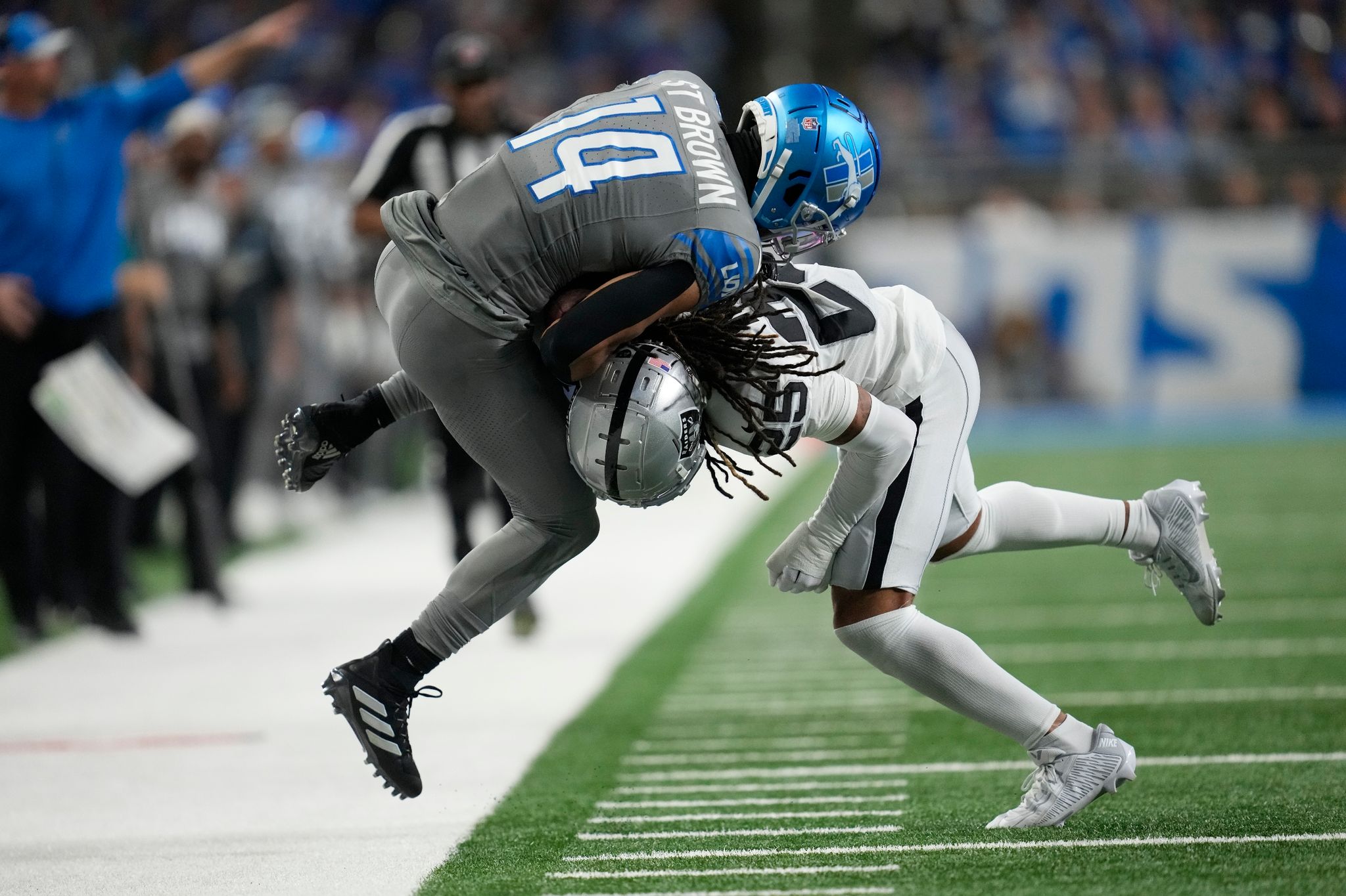 Detroit Lions Wide Receiver Amon-Ra St. Brown (14) Wird Von Las Vegas Raiders Safety Tre'von Moehrig (25) Aus Dem Spielfeld Gedrängt.