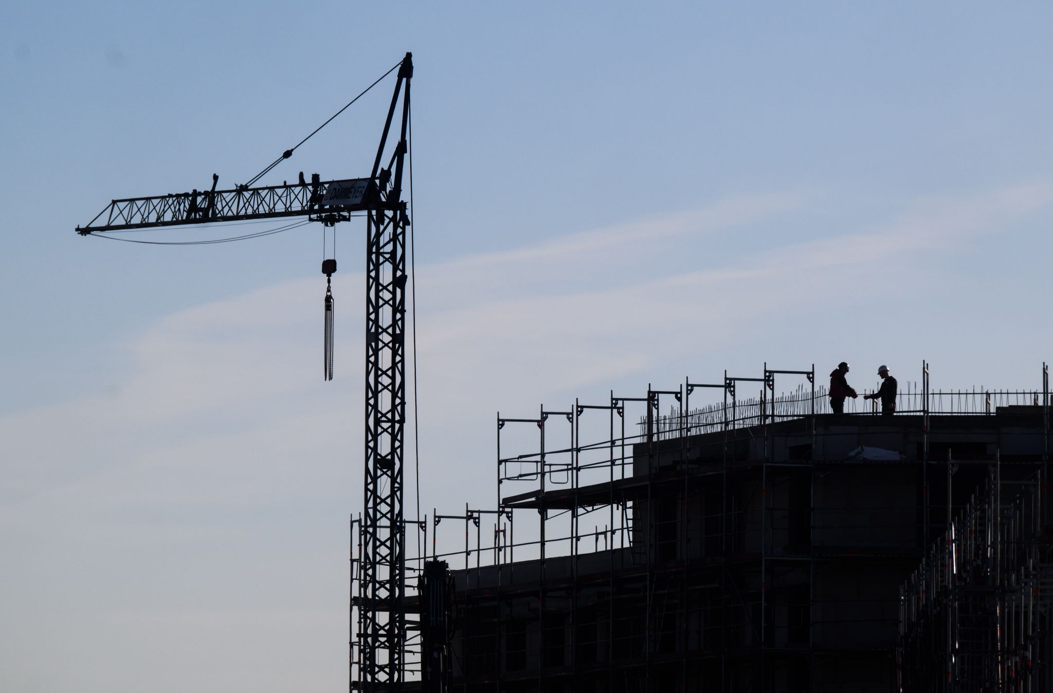 Bauarbeiter Stehen Auf Der Baustelle Eines Mehrfamilienhauses.