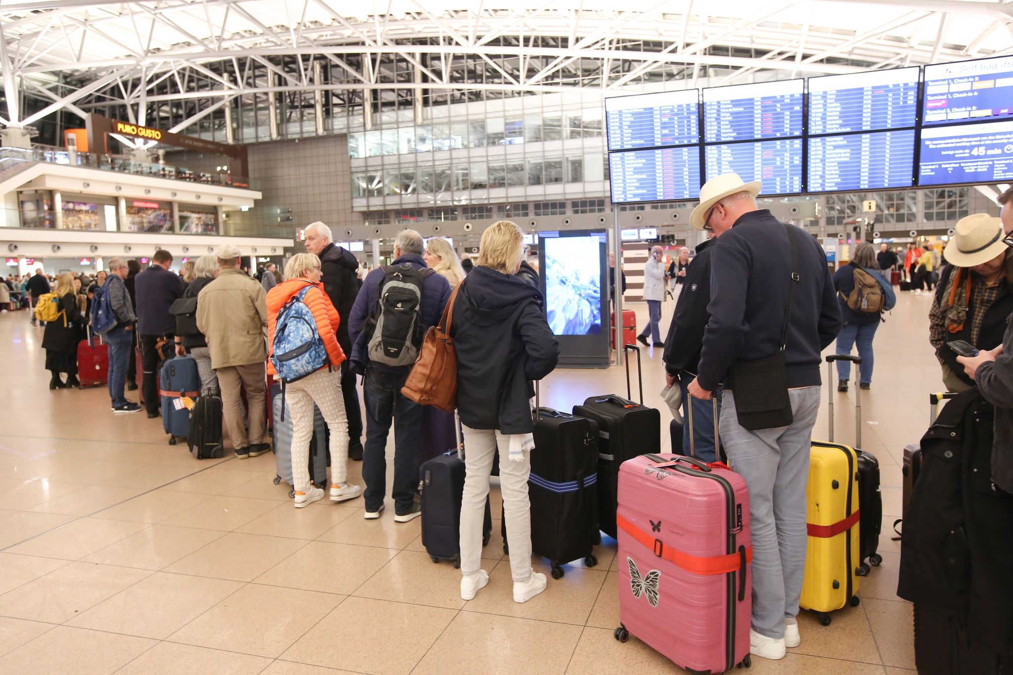 Reisende Stehen Im Terminal 1 Am Hamburger Flughafen In Einer Schlange.