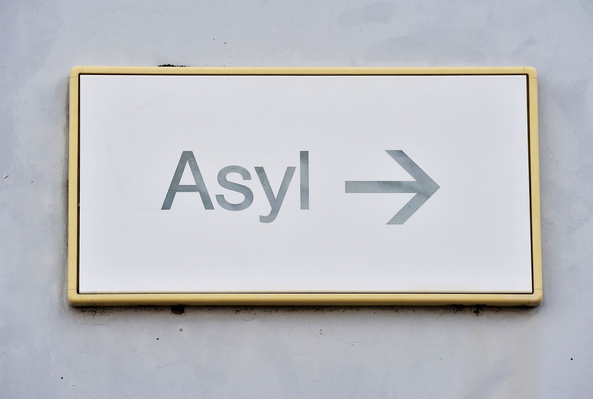 Ein Schild Mit Der Aufschrift «Asyl» Hängt An Einer Wand.