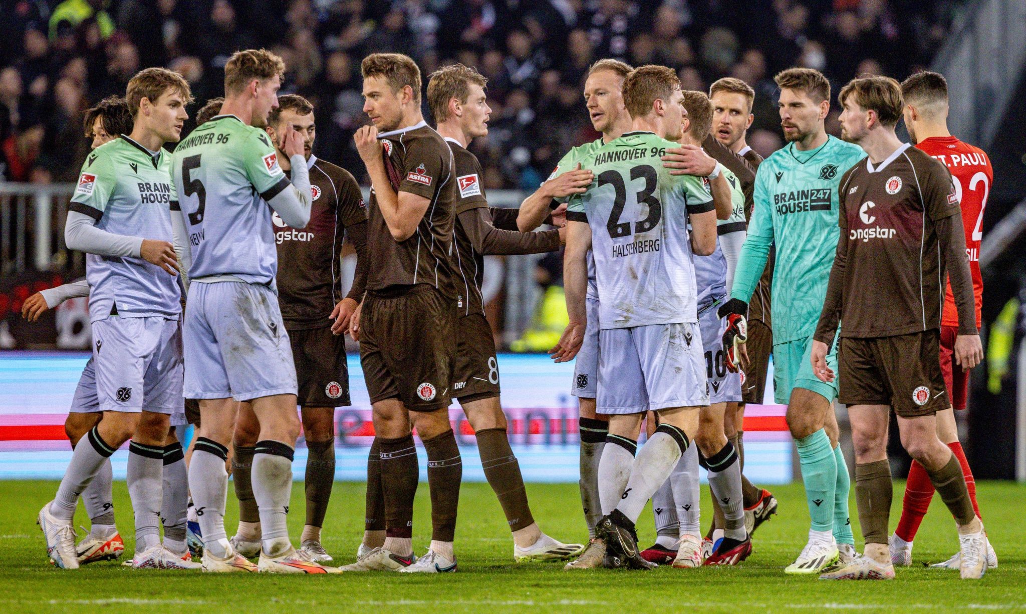 Spieler Beider Mannschaften Stehen Nach Dem Abpfiif Auf Dem Platz.