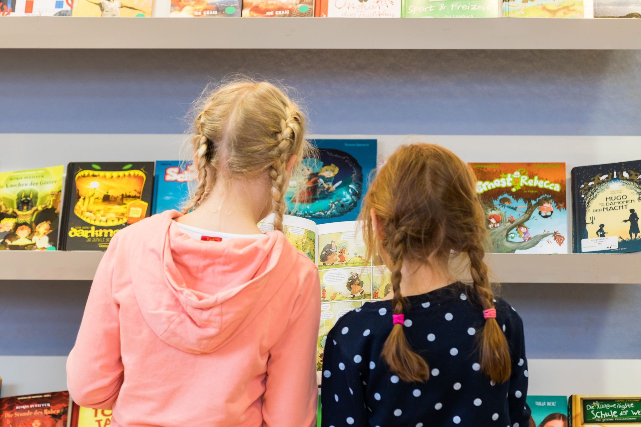Zwei Mädchen Stehen Bei Der «Kibum» (Kinder- Und Jugendbuchmesse) In Der Stadtbibliothek PFL.