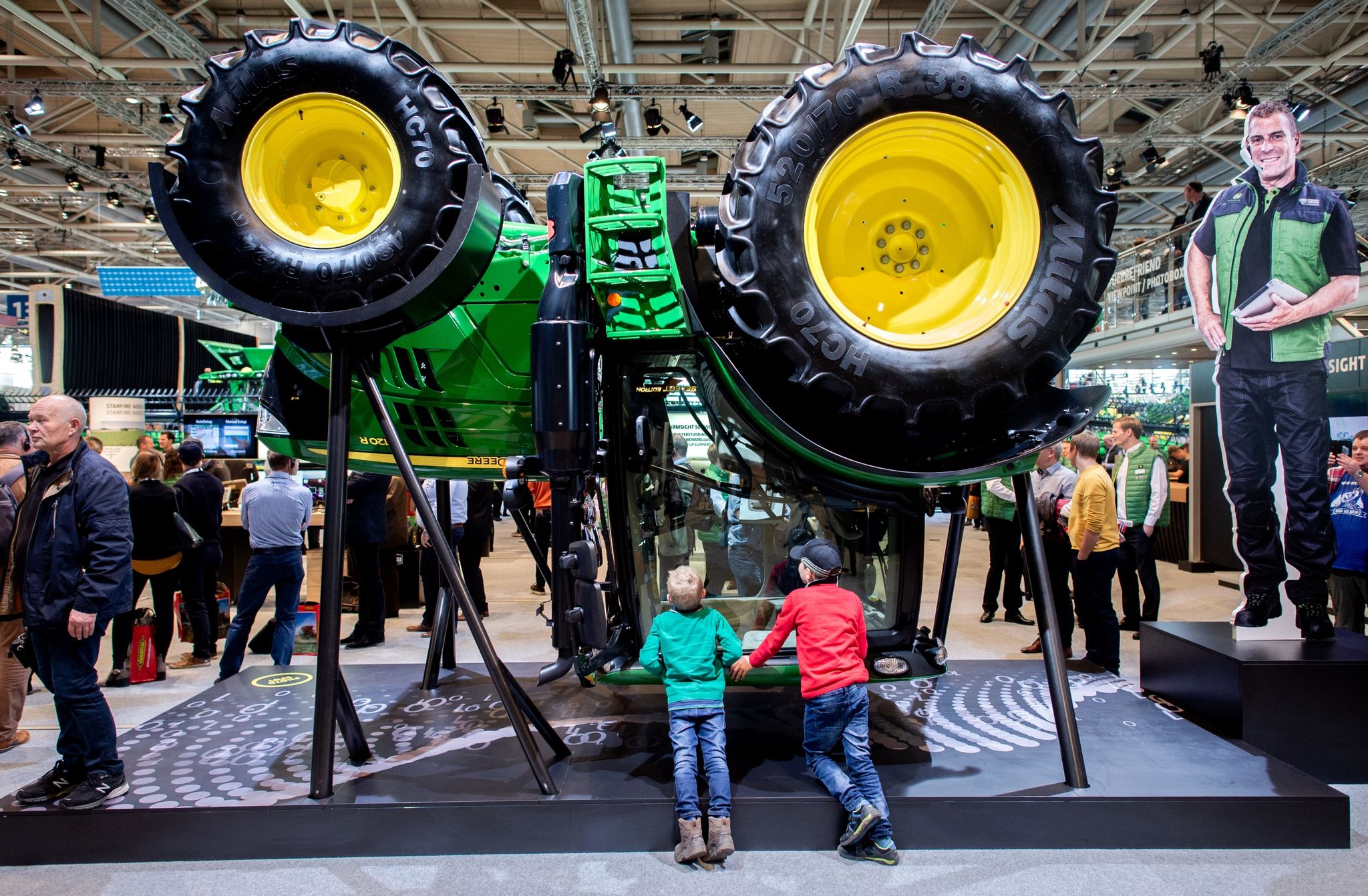 Zwei Jungen Betrachten Am Stand Von John Deere Auf Der Landtechnik-Messe Einen Traktor.