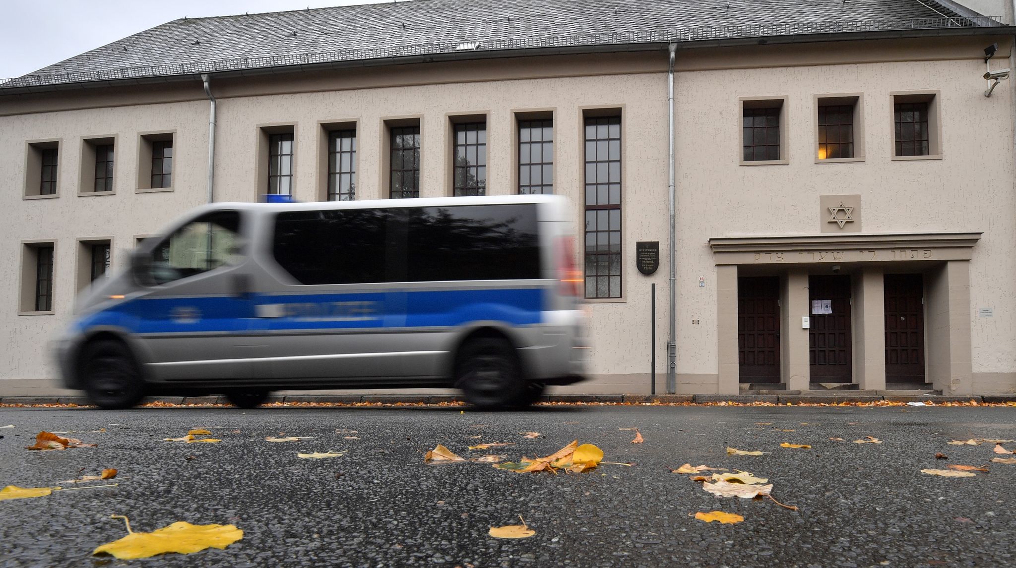 Ein Polizeifahrzeug Fährt Vor Der Neuen Synagoge In Erfurt Entlang.