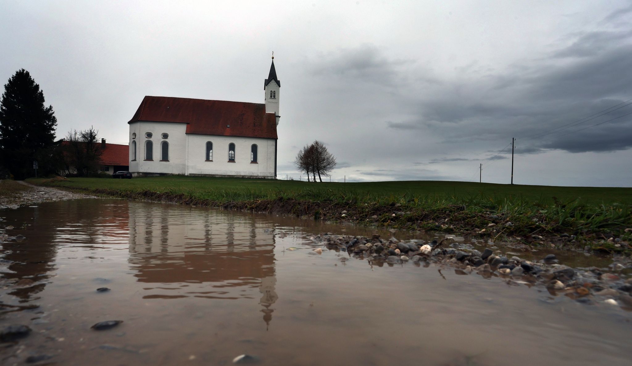 Regenwolken über Der Wallfahrtskirche Sankt Alban Im Bayerischen Aitrang.