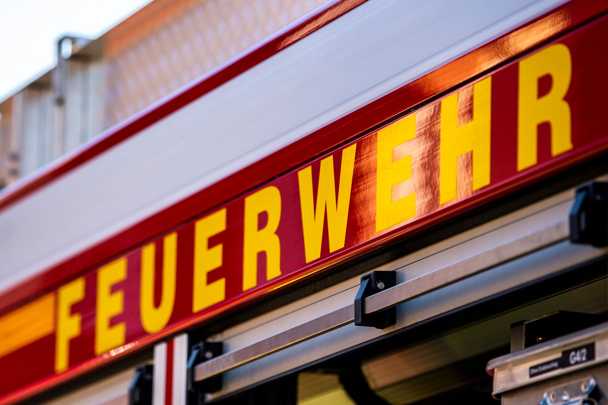 Auf Dem Einsatzfahrzeug Ist In Gelber Farbe Der Schriftzug «Feuerwehr» Zu Lesen.