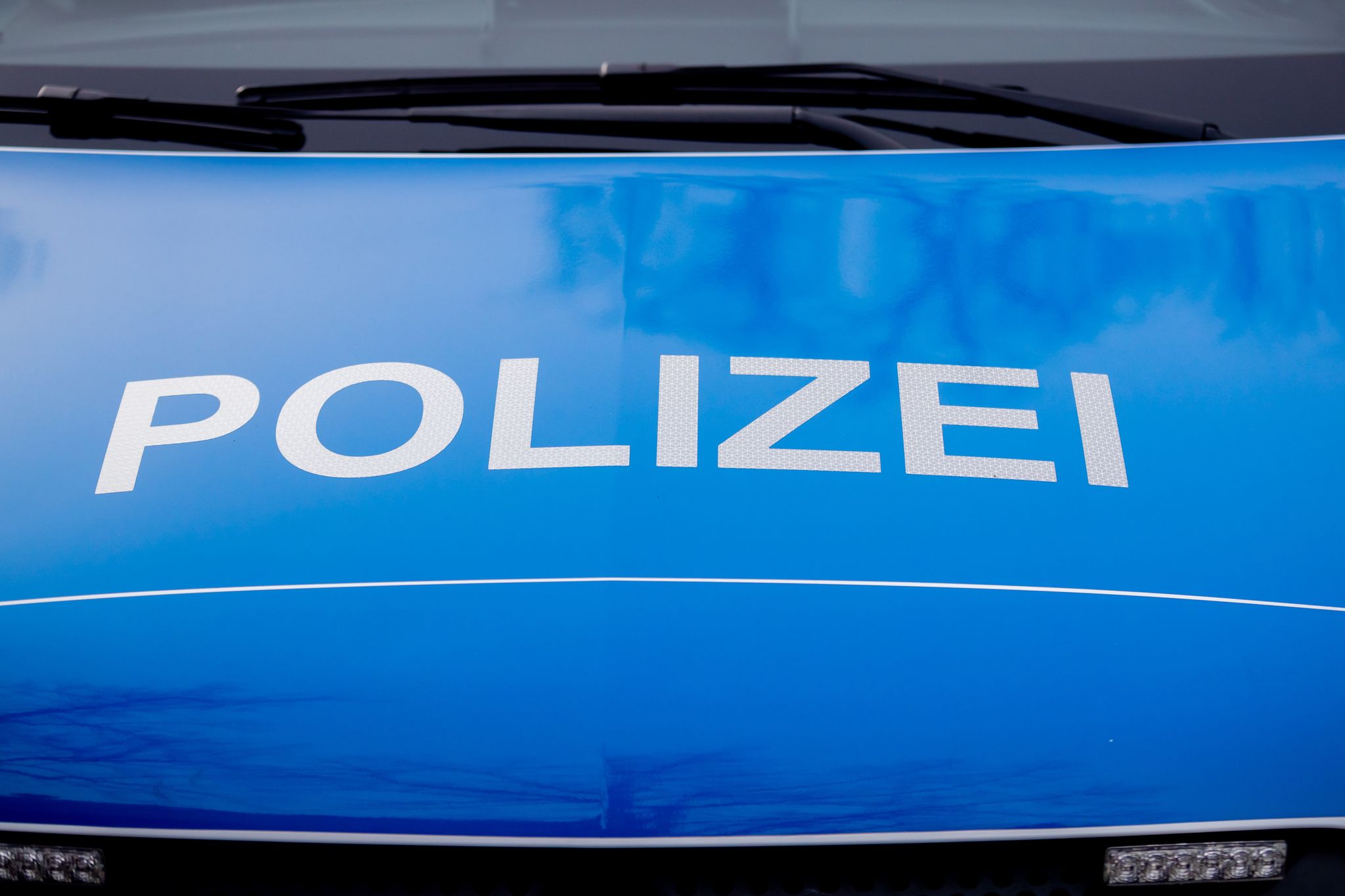 Der Polizei-Schriftzug Steht Auf Einem Einsatzfahrzeug.